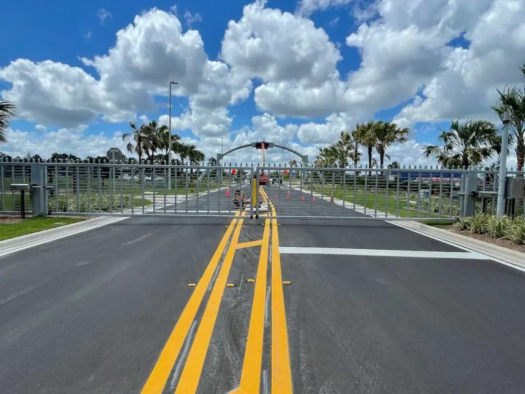 A wide-angle view of the ornamental gates at the SunTrax facility, highlighting their sleek design and secure installation with HydraSwing operators.